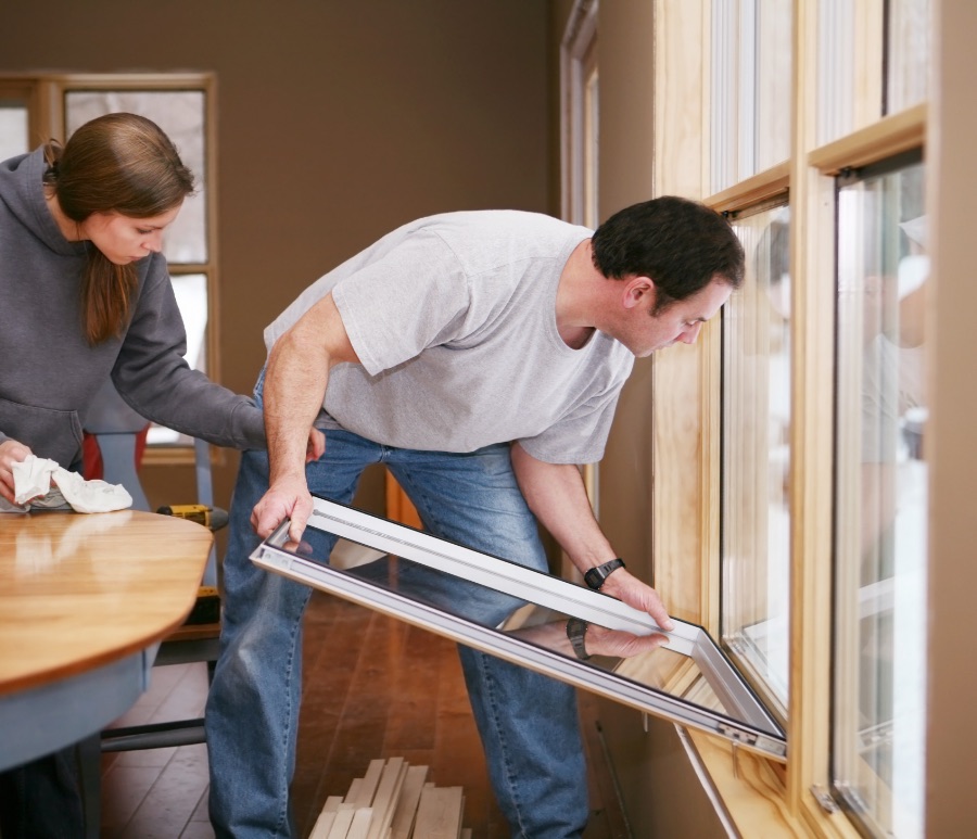 Woman and man replacing windows